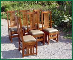 Set of six dining chairs in a light stain color, upholstered in a light green leather. 